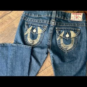 TRUE RELIGION flare jeans with gold accents.